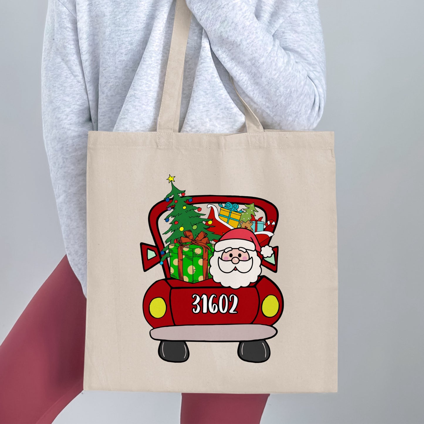 Tote bag with Santa in a red truck, Christmas tree, presents, and number 31602.