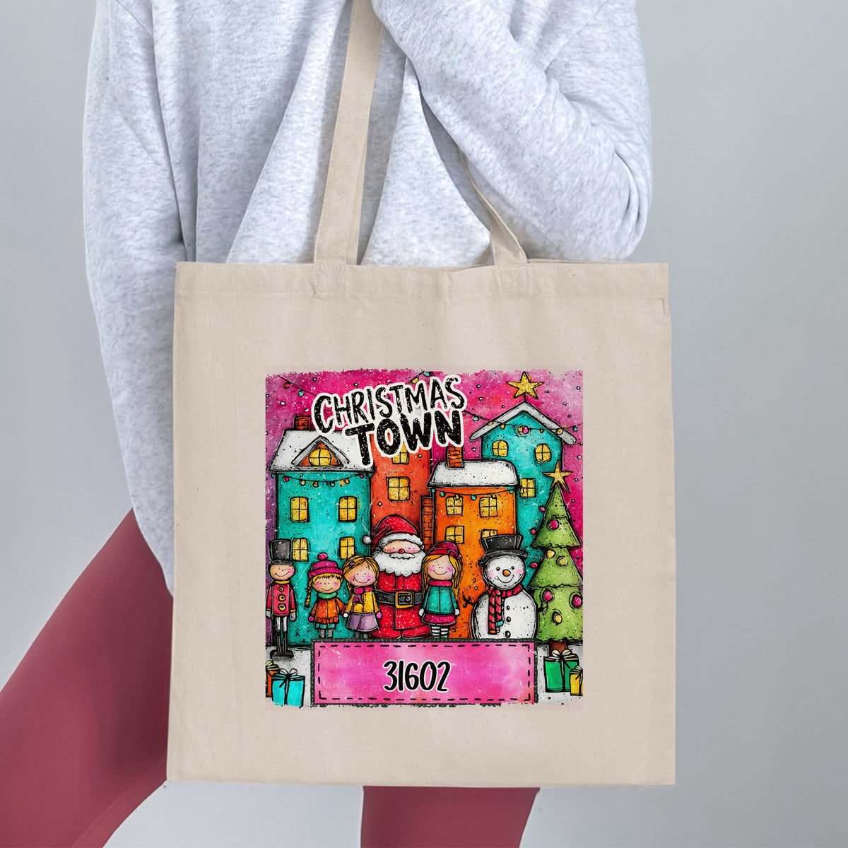 Tote bag featuring Christmas Town illustration with Santa, children, snowman, and zip code 31602.