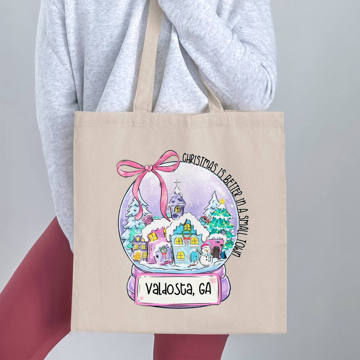 Tote bag with a snow globe design featuring "Christmas is better in a small town" and "Valdosta, GA".