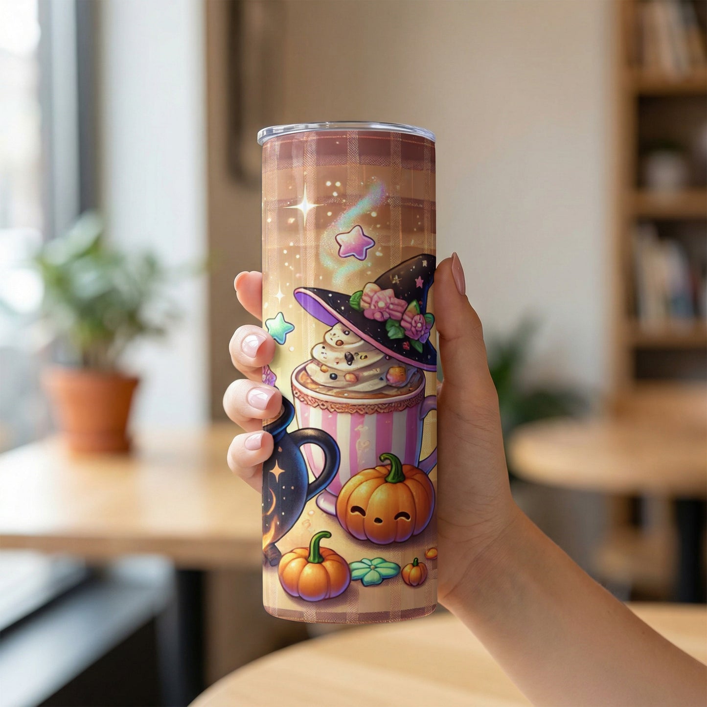 Tumbler with witch hat, coffee, pumpkins, and stars, held by a hand.