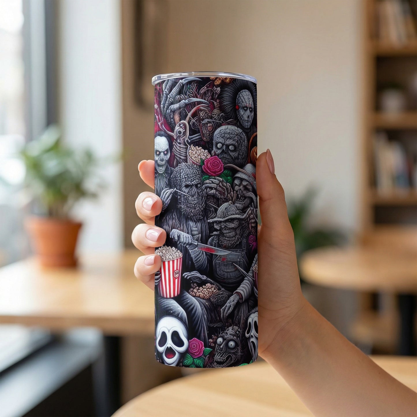 Tall tumbler with a collage of spooky characters, skulls, popcorn, and roses.