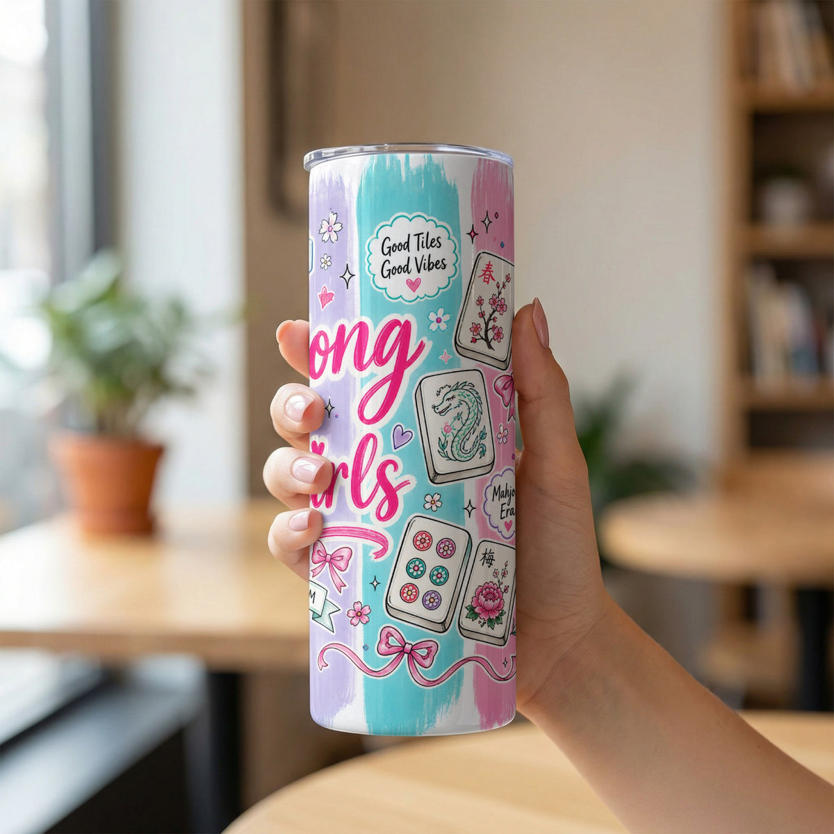 Tumbler with "Long Girls" text and mahjong tiles design, held by a hand.