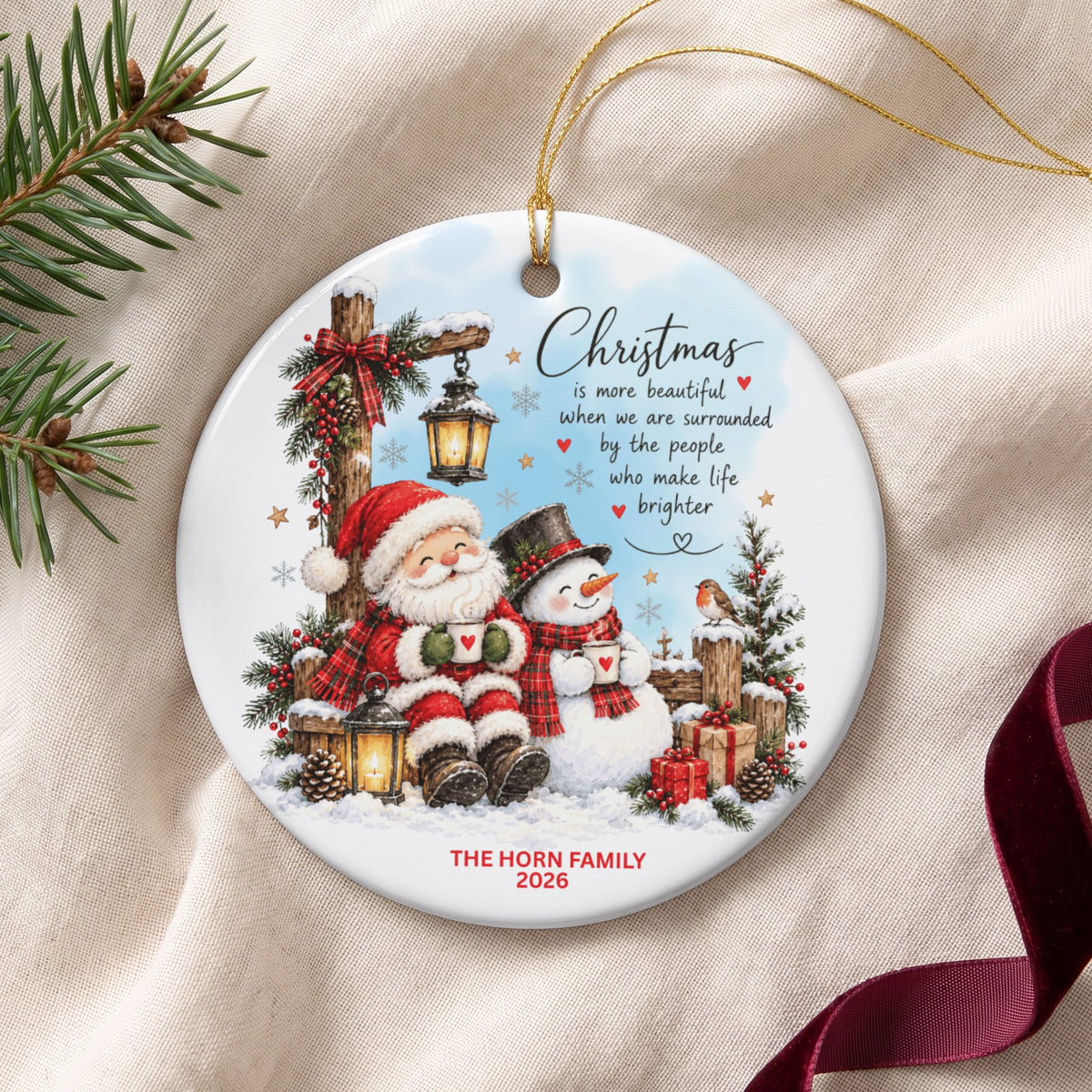 Round ceramic Christmas ornament featuring Santa and a snowman, text about family, and custom text THE HORN FAMILY 2026.