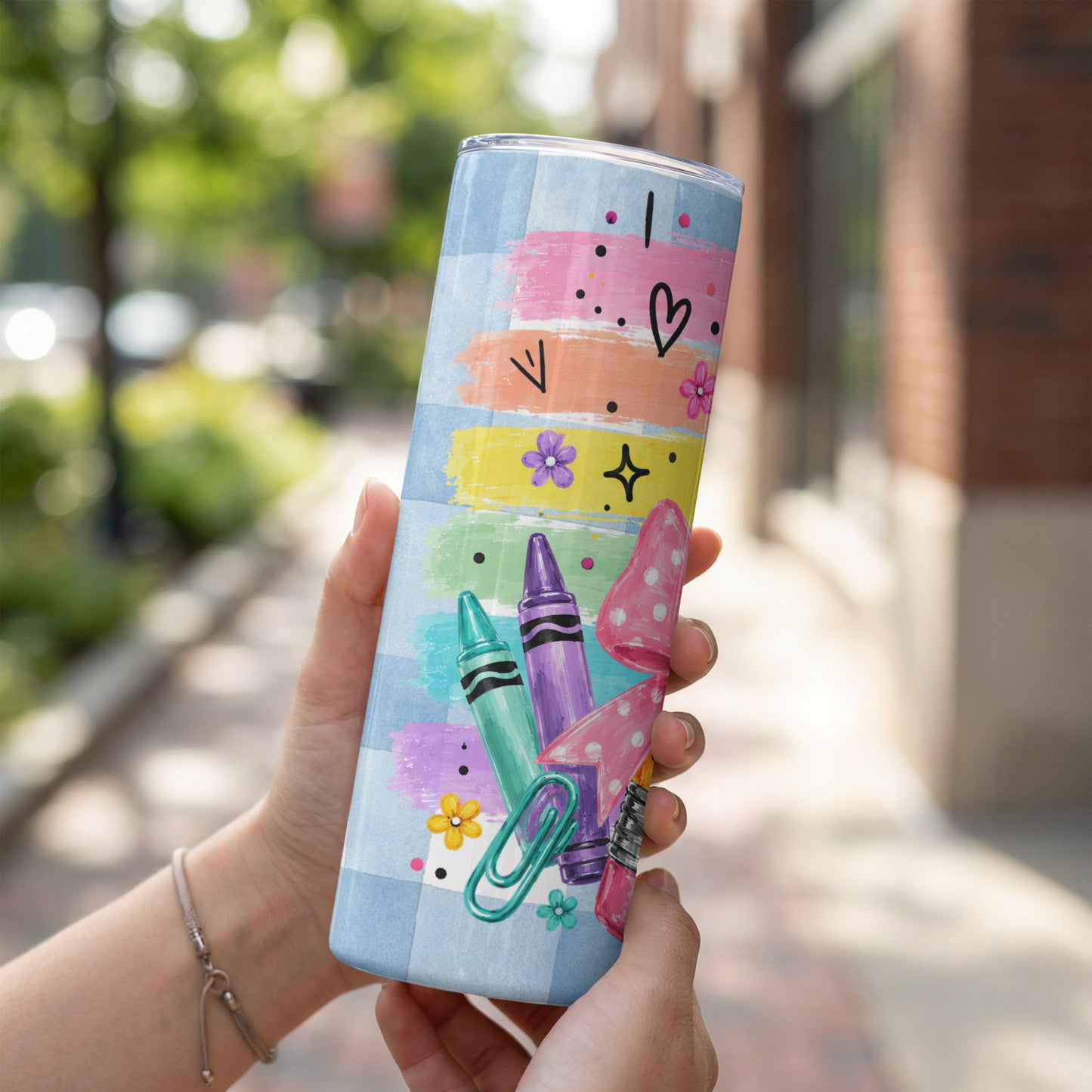 Tumbler with blue gingham, crayons, polka dots, and floral designs.