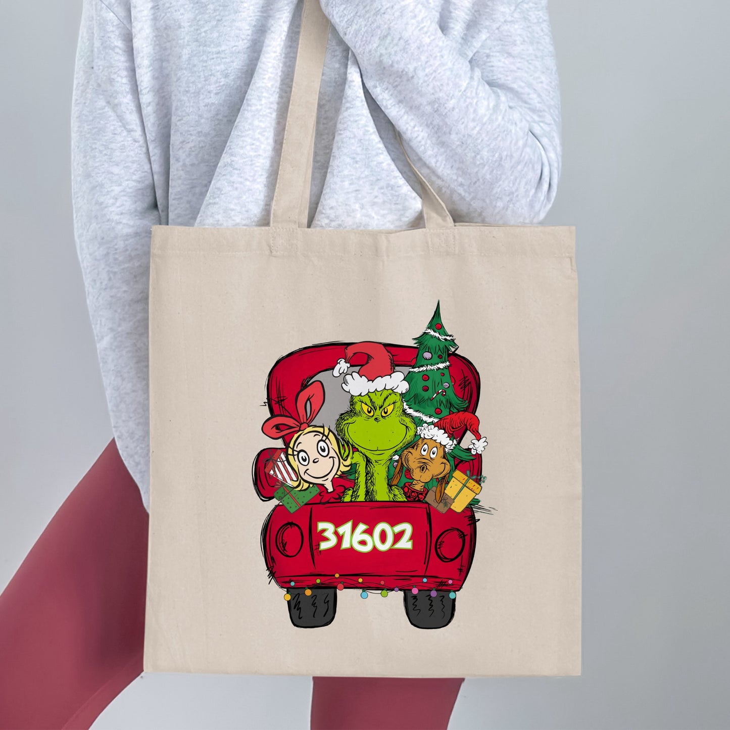 Grinch, Cindy Lou Who, Max, and a Christmas tree in a red truck with "31602"