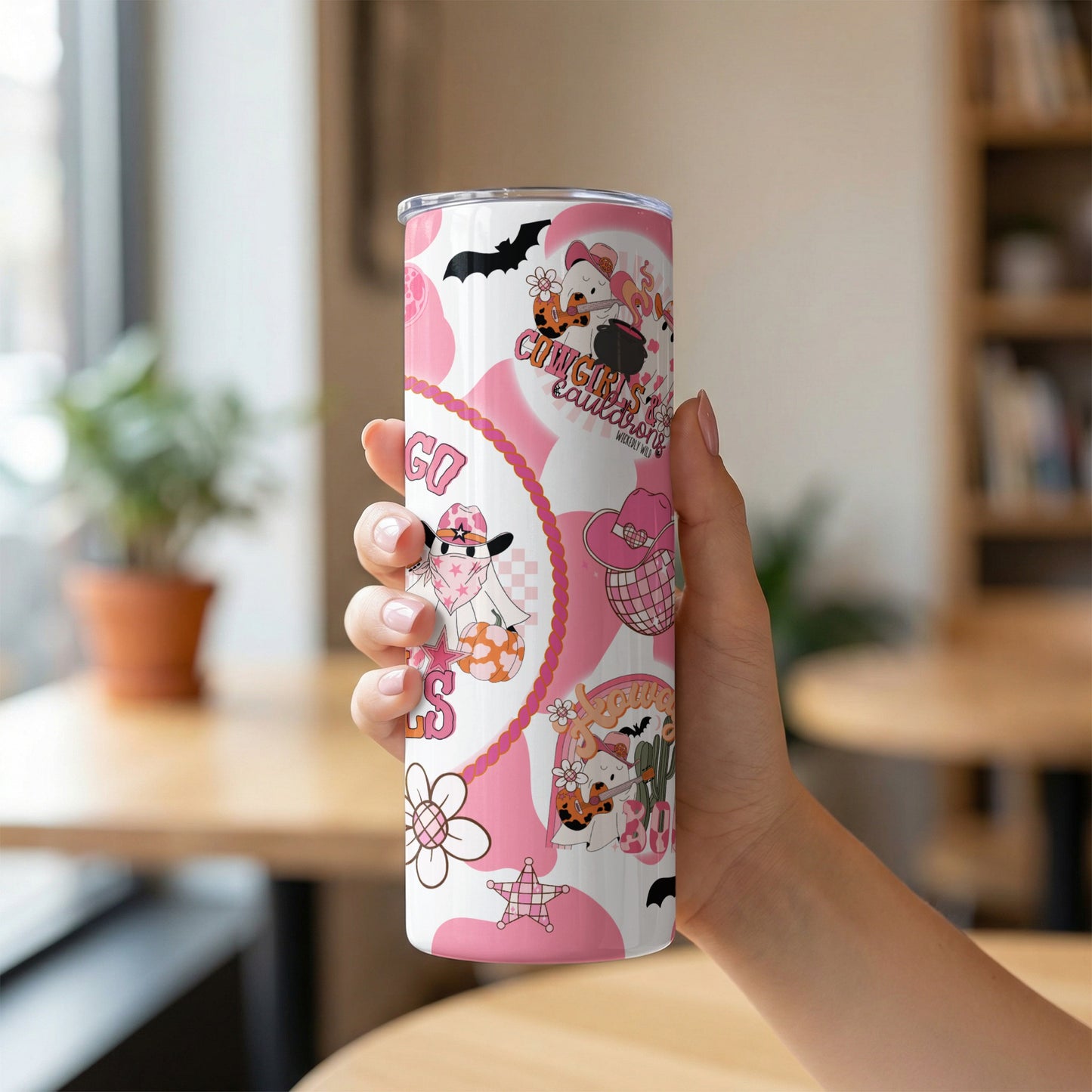 Tall tumbler with pink and white cowgirl and Halloween cartoon patterns.