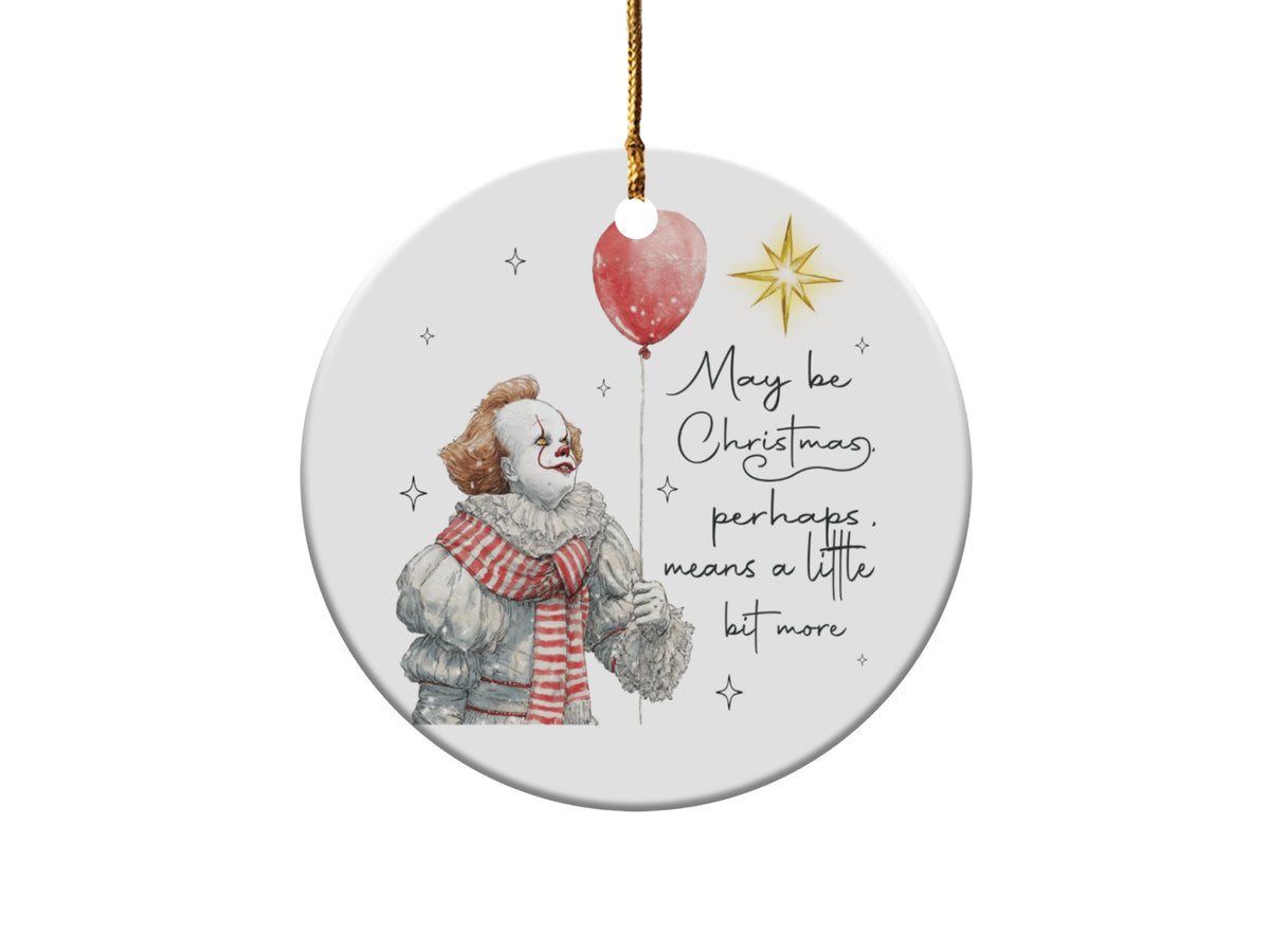 Round ornament with Pennywise holding a red balloon and text "May be Christmas, perhaps. means a little bit more".