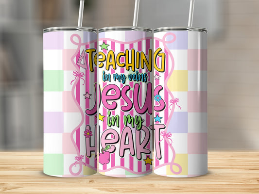 Tumbler with "Teaching in my veins Jesus in my heart" text and pastel checkered pattern.