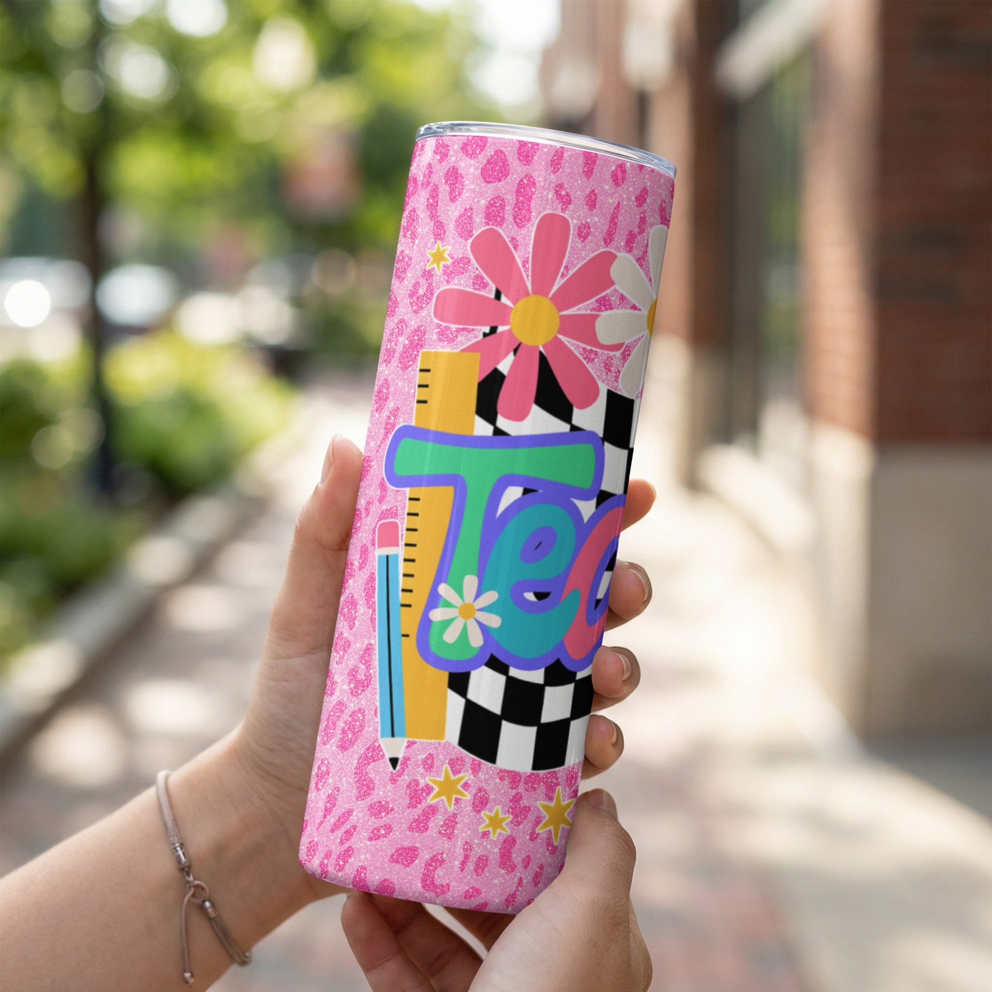 Tumbler with pink leopard print, flowers, pencil, ruler, and "Teacher" text.