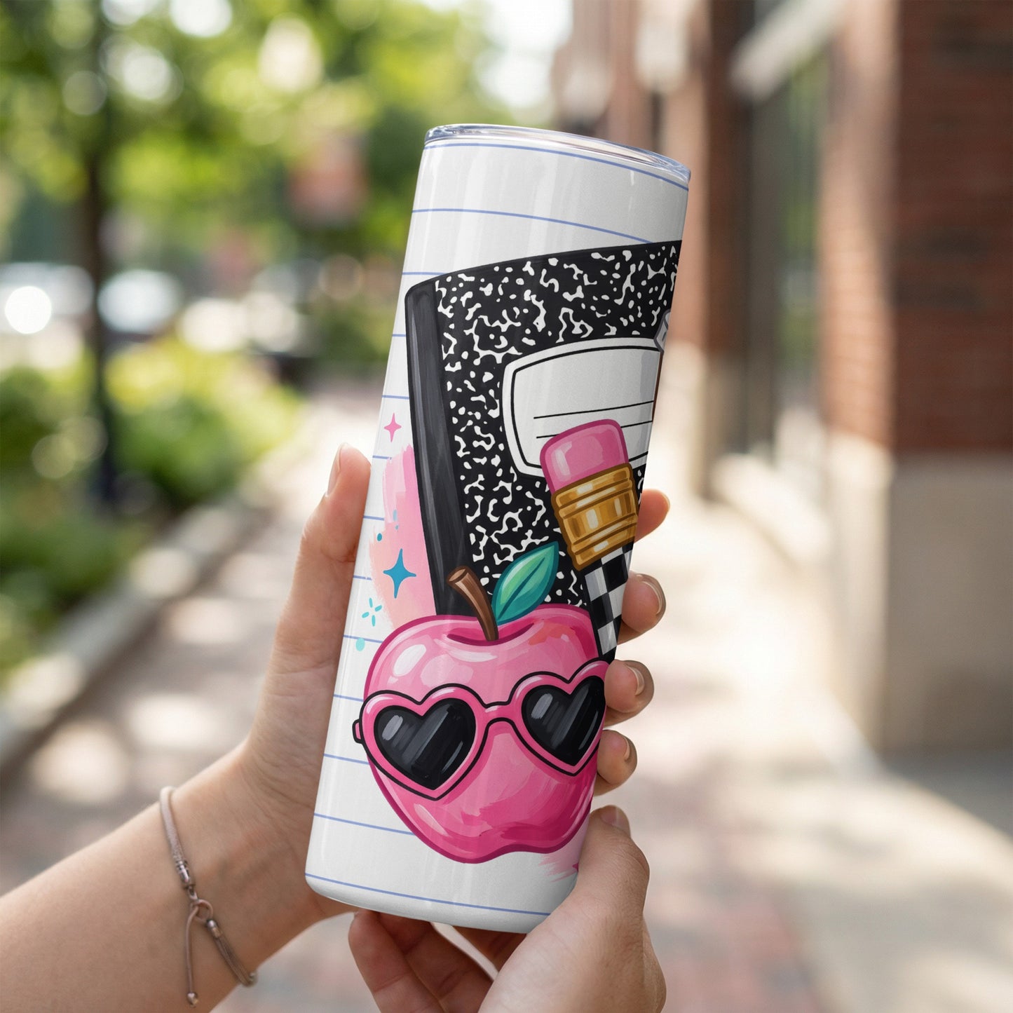 White tumbler with notebook paper design featuring a pink apple in heart sunglasses.