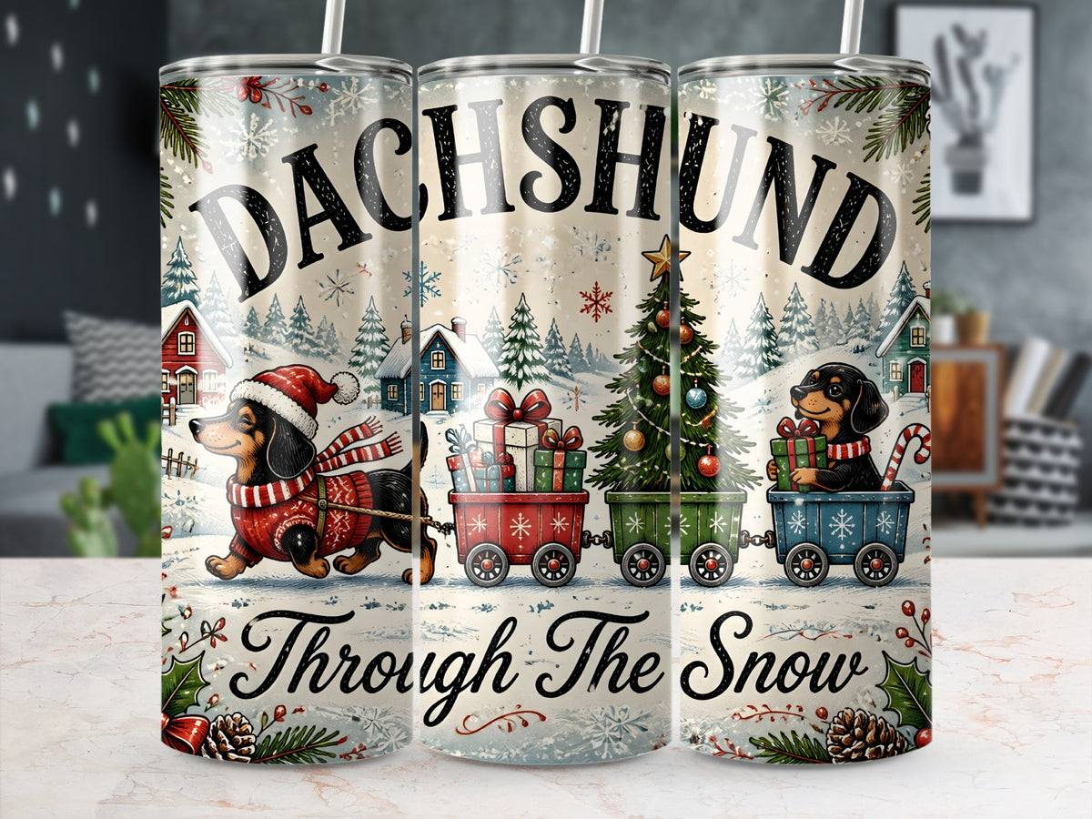 Three matching metal tumblers display a vintage-style Christmas illustration of dachshunds pulling gift carts through snow.