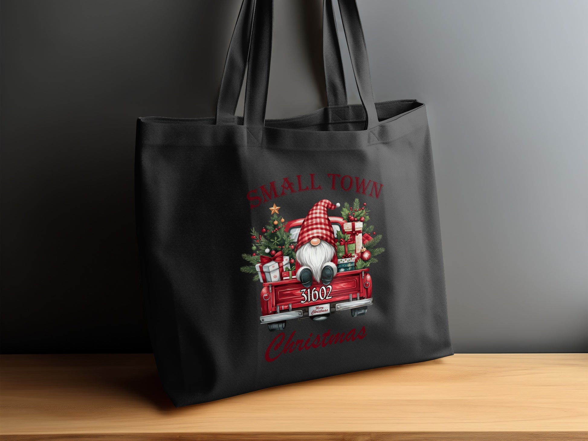 Black tote bag with a Christmas gnome in a red truck design, text reads "Small Town Christmas".