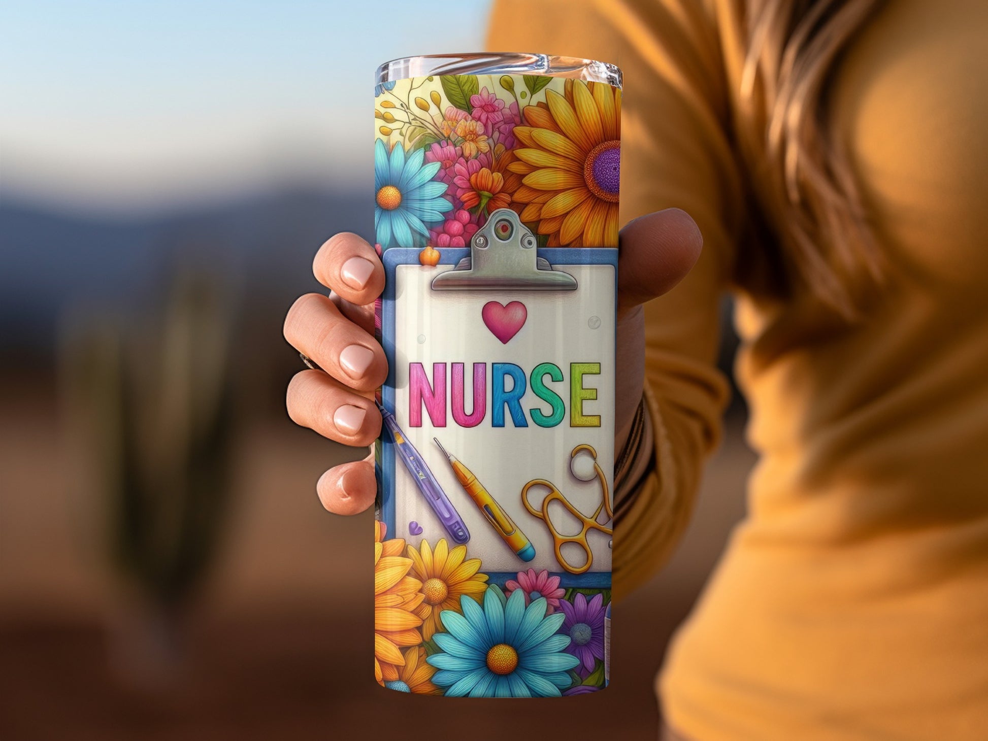 Tumbler with "Nurse" text, heart, flowers, scissors, and pens on clipboard.