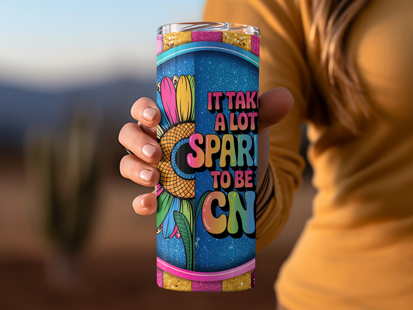 Tumbler with colorful flower and text "It takes a lot to sparkle".