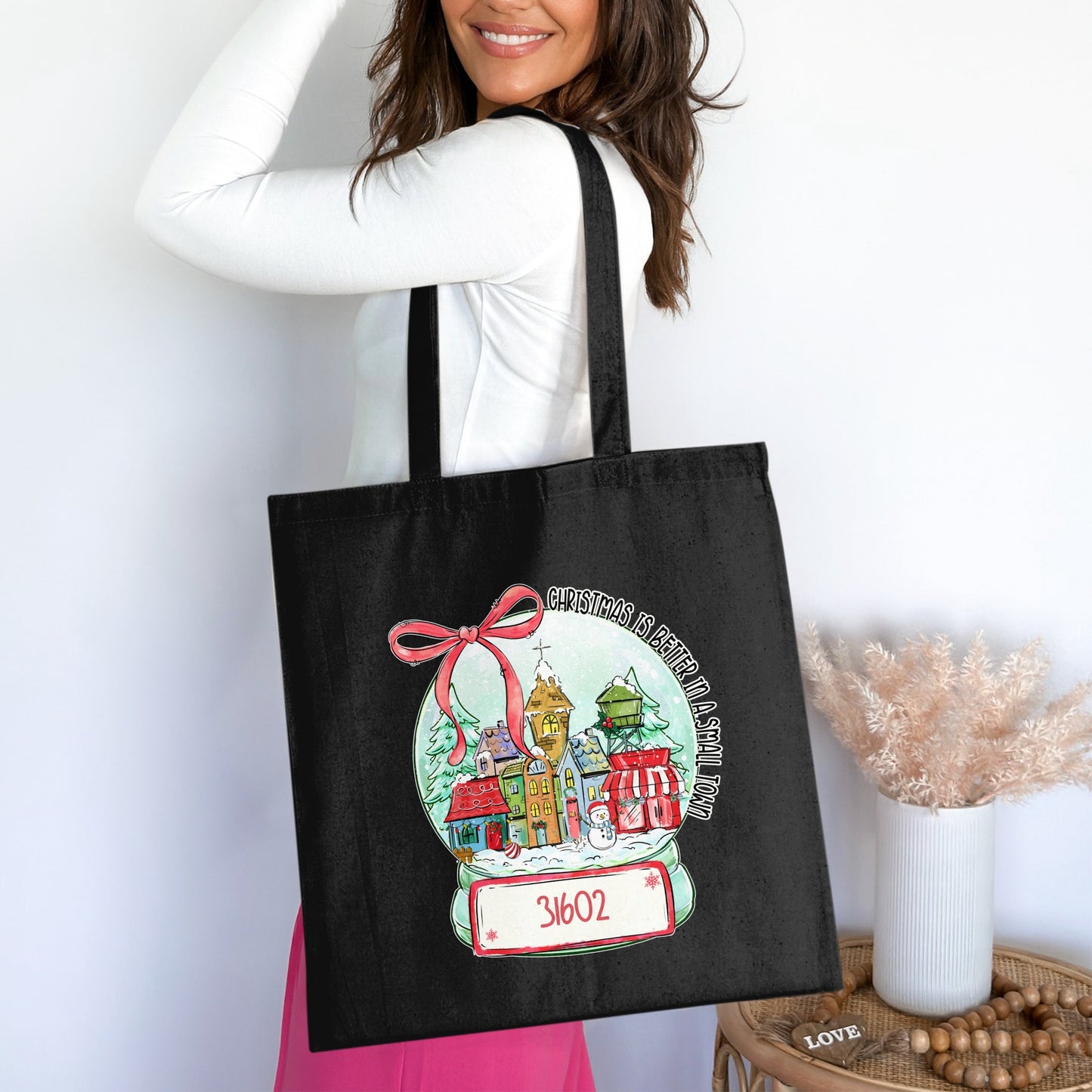 Black tote bag with Christmas snow globe design and zip code 31602.