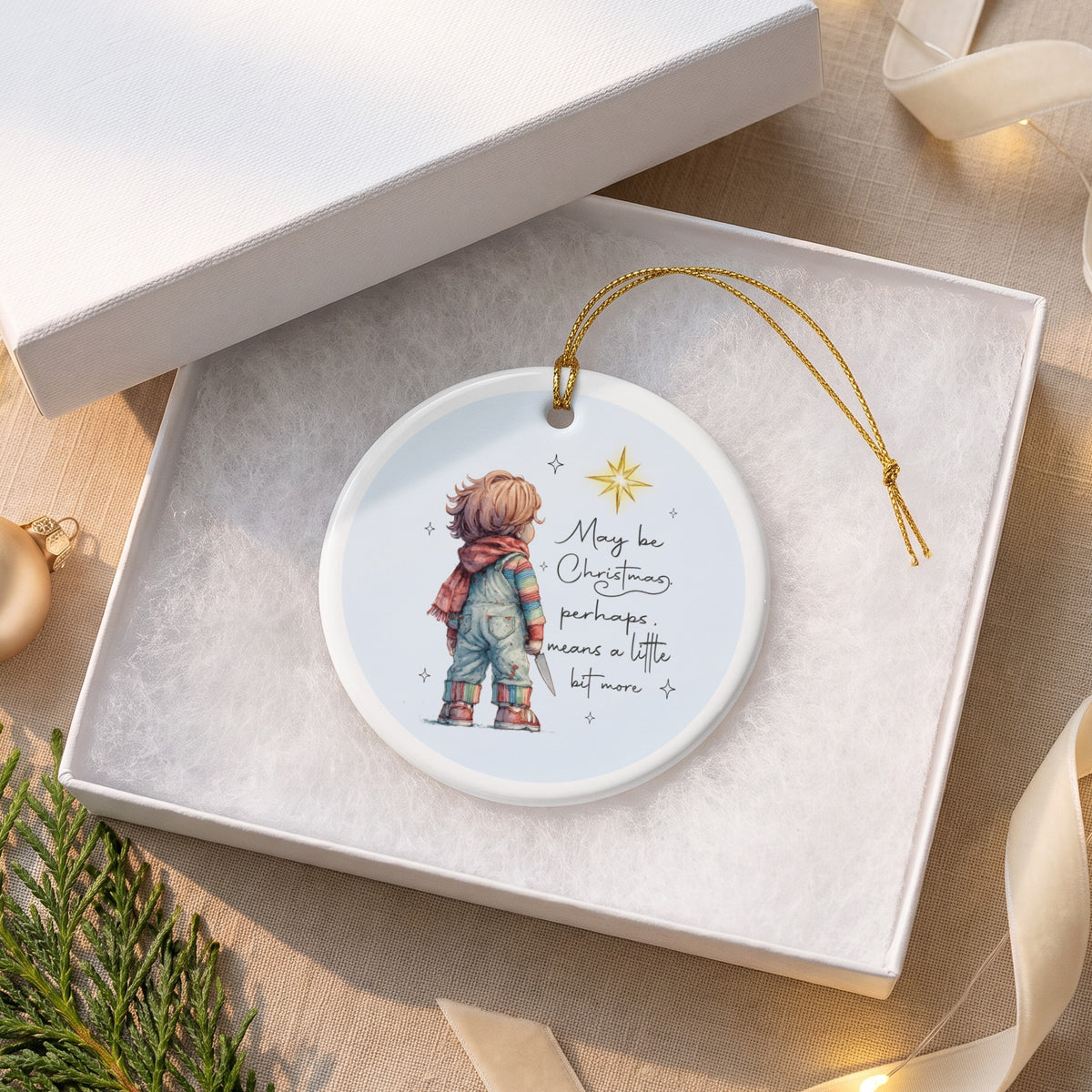 Round ornament with a doll holding a knife, text "May be Christmas, perhaps, means a little bit more".