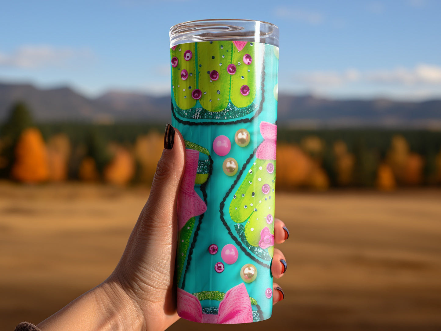 Hand holds teal tumbler with pink bow and green Christmas tree design.