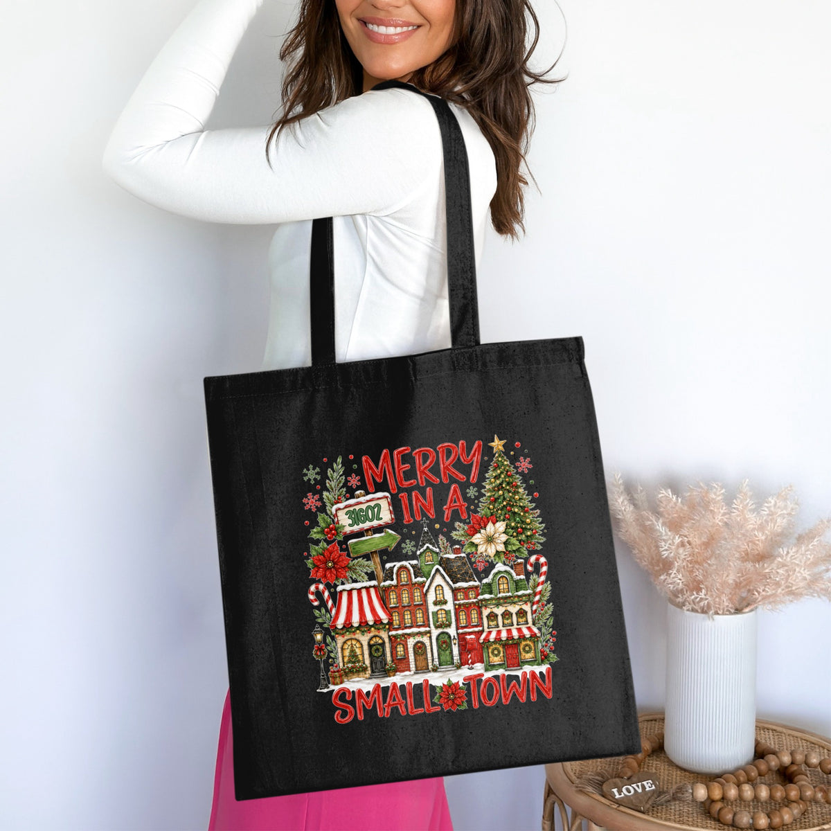 Black tote bag with "Merry in a Small Town" holiday village graphic.