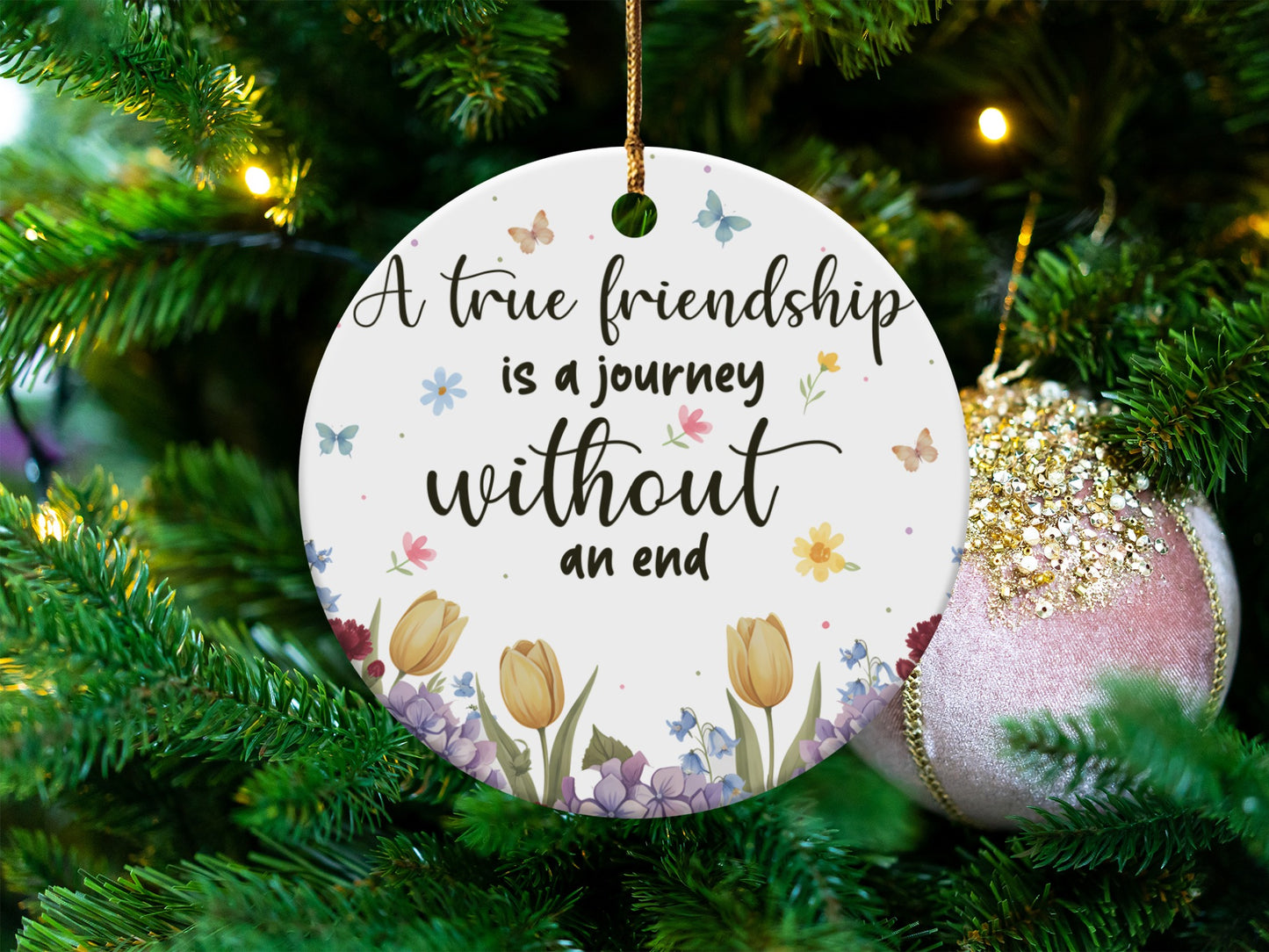 Round ornament with "A true friendship is a journey without an end" quote and floral design.