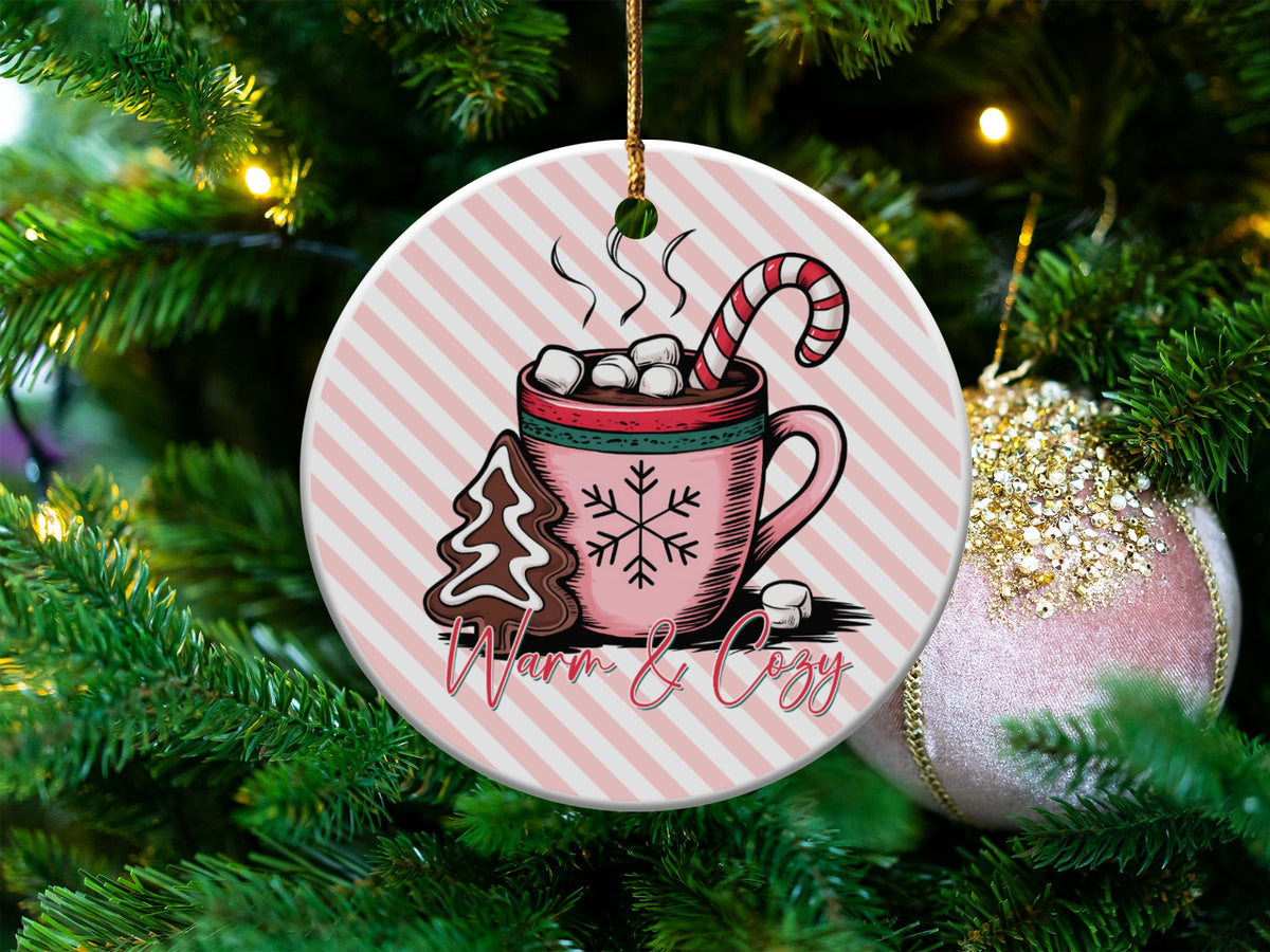Round ornament with hot chocolate, candy cane, gingerbread tree, and "Warm & Cozy" text.