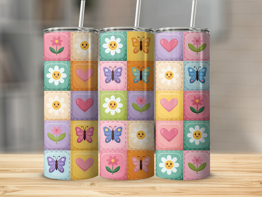 Quilted pattern of flowers, hearts, and butterflies on a tumbler.