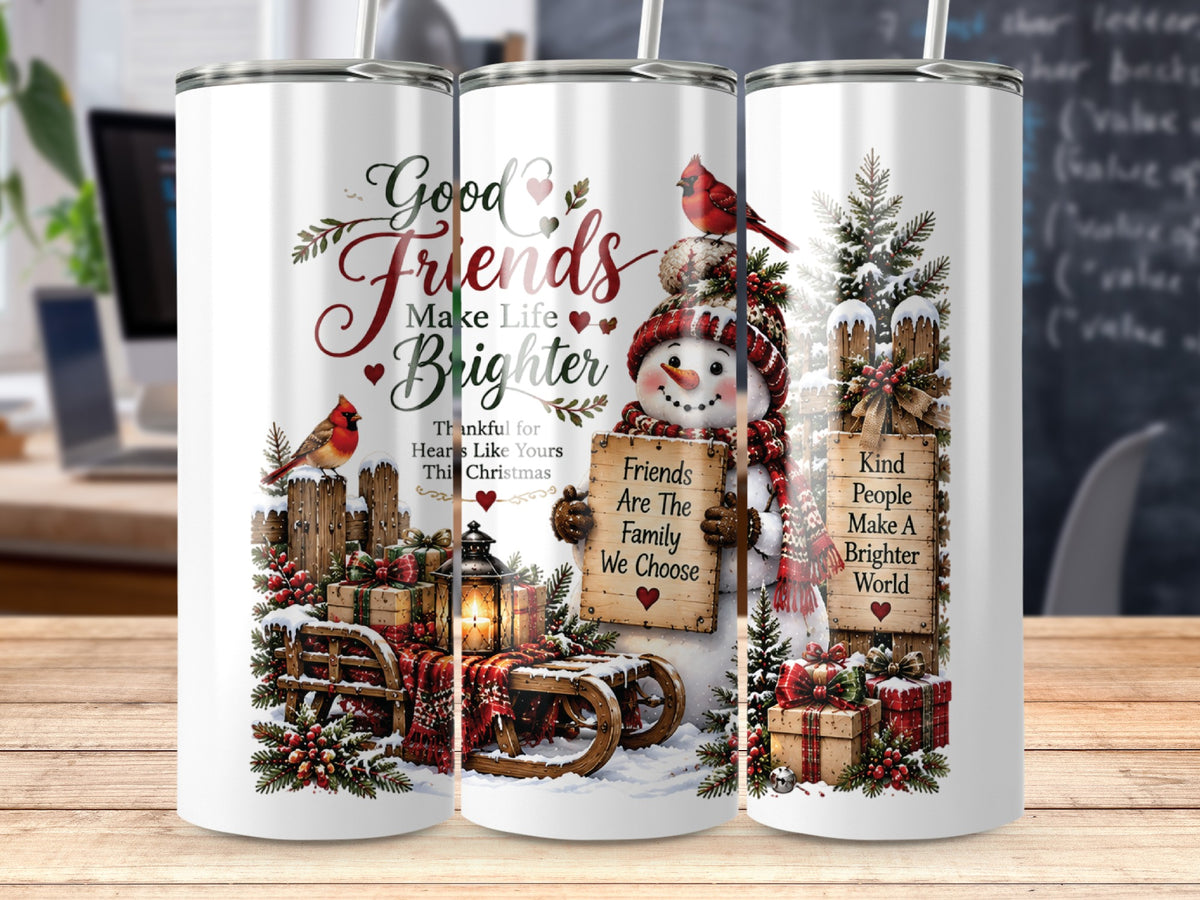 Three cylindrical stainless steel tumblers stand on a wooden surface, featuring Christmas-themed winter graphics with snowmen and cardinals.