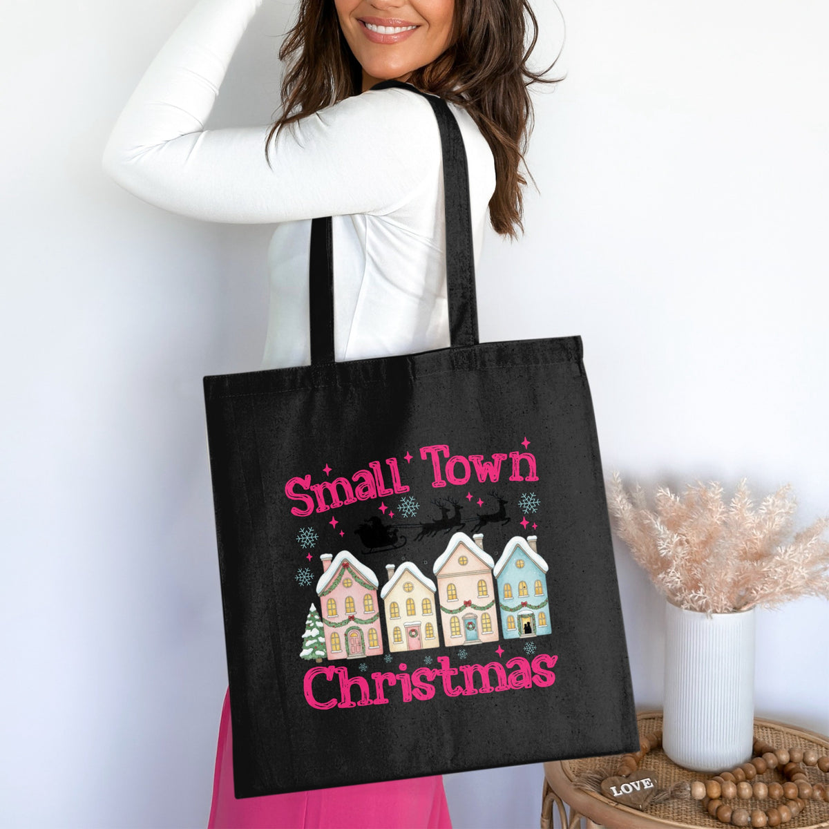 Black tote bag with "Small Town Christmas" text and winter village graphic.