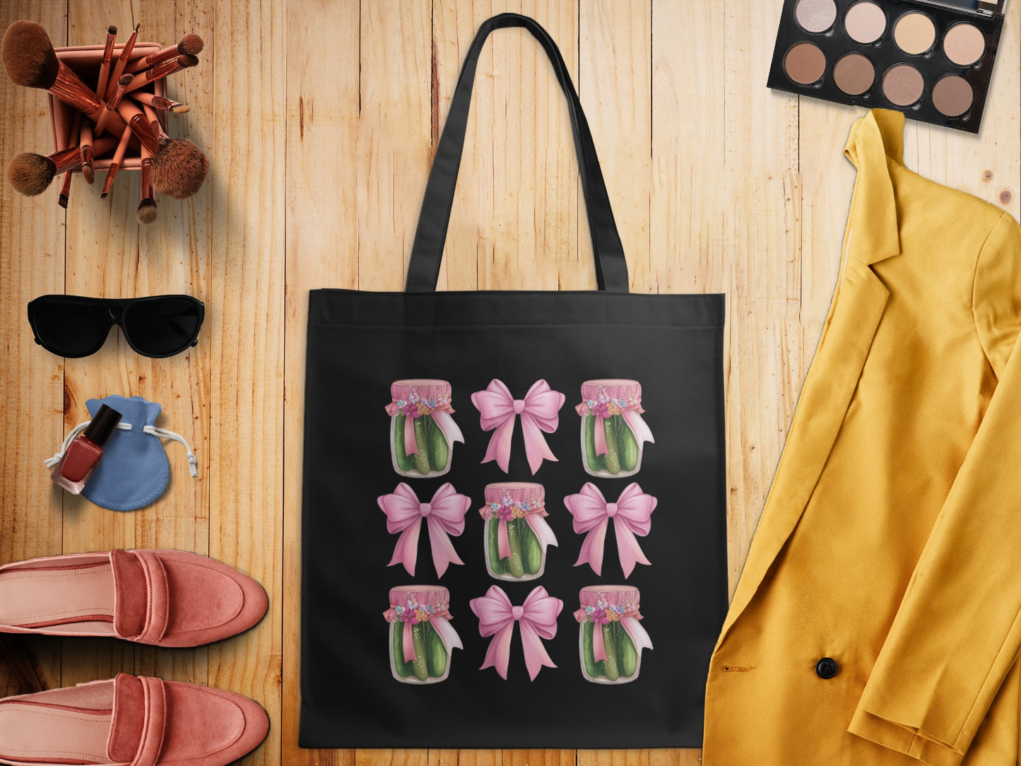 Black tote bag with repeating pattern of jars of pickles tied with pink bows.