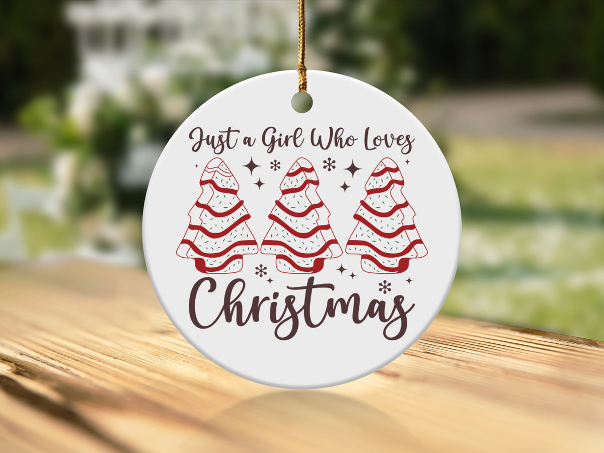 Round Christmas ornament with trees and text "Just a Girl Who Loves Christmas".
