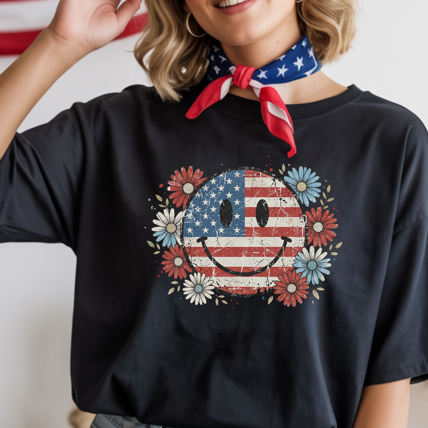 Person wearing a black t-shirt with a smiley face design featuring American flag colors and flowers.