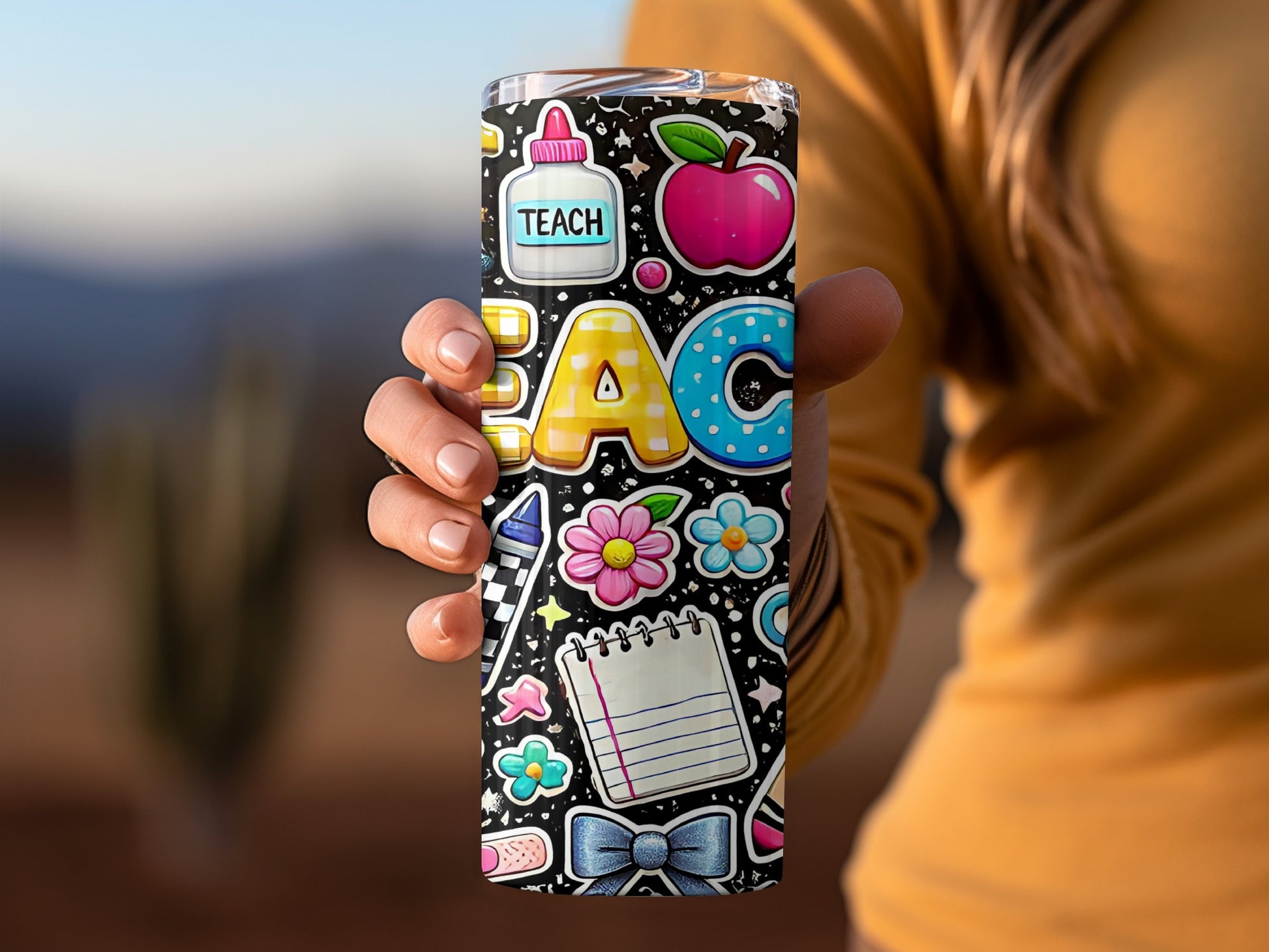 Tumbler with colorful teacher-themed cartoon graphics including "TEACH", apple, and school supplies.