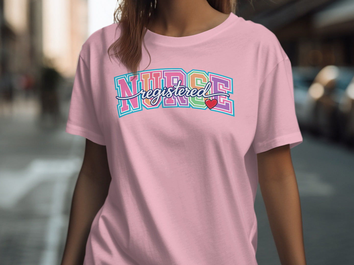 Pink t-shirt with "REGISTERED NURSE" in colorful collegiate font and a small red heart.