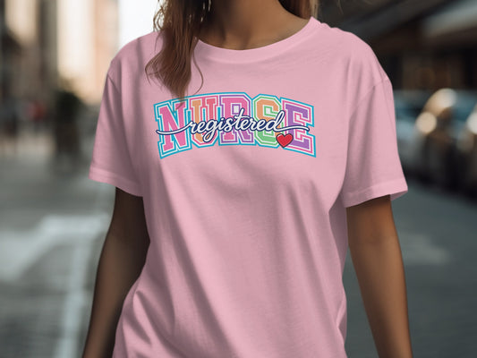 Pink t-shirt with "REGISTERED NURSE" in colorful collegiate font and a small red heart.