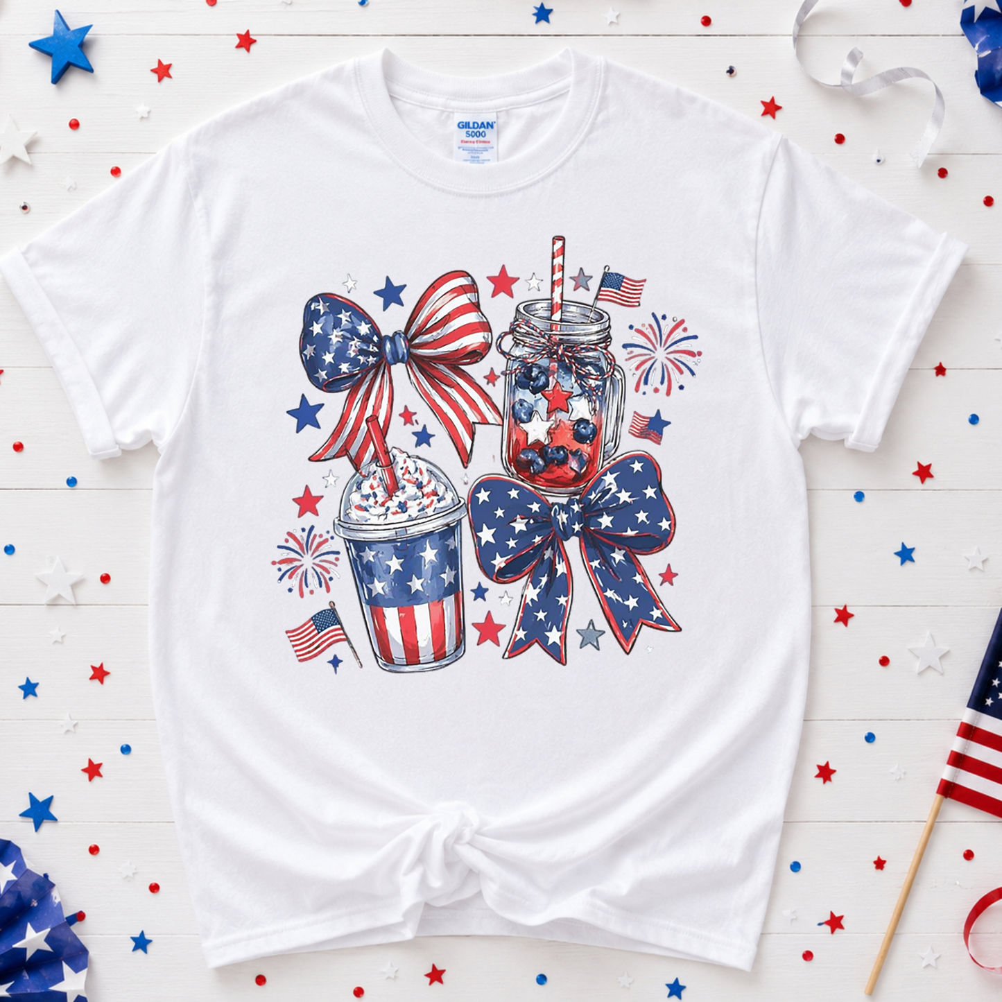 White t-shirt with patriotic design featuring bows, jars, and stars on a wooden surface with decorative elements.