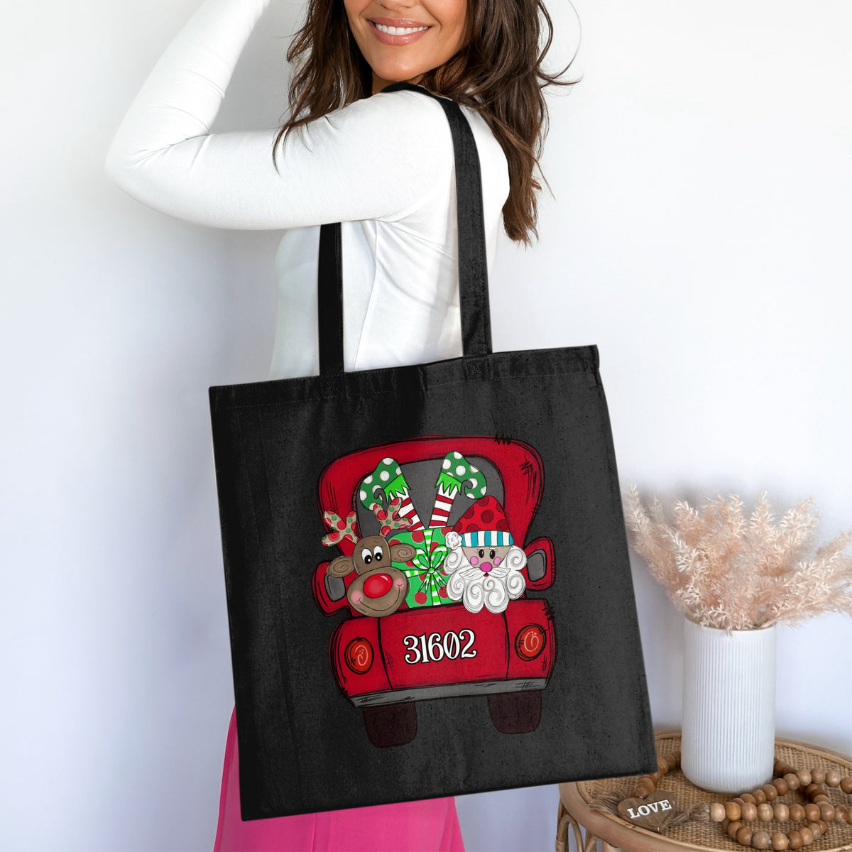 Black tote bag with a red truck carrying Santa, reindeer, and gifts.