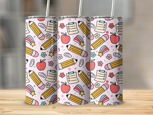 Pink tumbler with a cartoon pattern of pencils, apples, flowers, and stars.