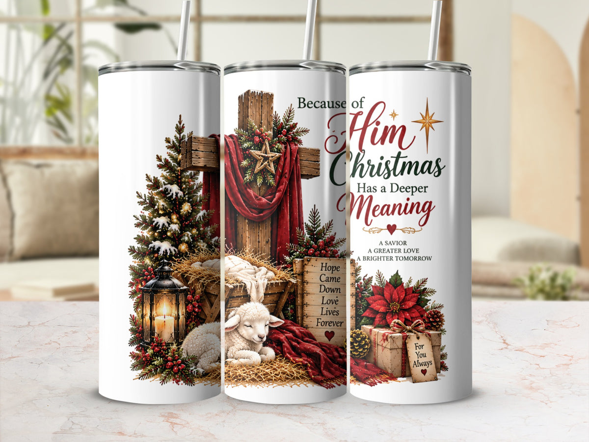 Three tall, white tumblers stand side-by-side on a light countertop, displaying a Christian Christmas design with a cross, a manger, and text reading Because of Him Christmas Has a Deeper Meaning.