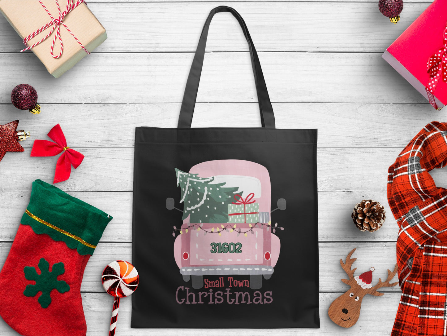 Black tote bag with pink truck, Christmas tree, gifts, and "Small Town Christmas" text.