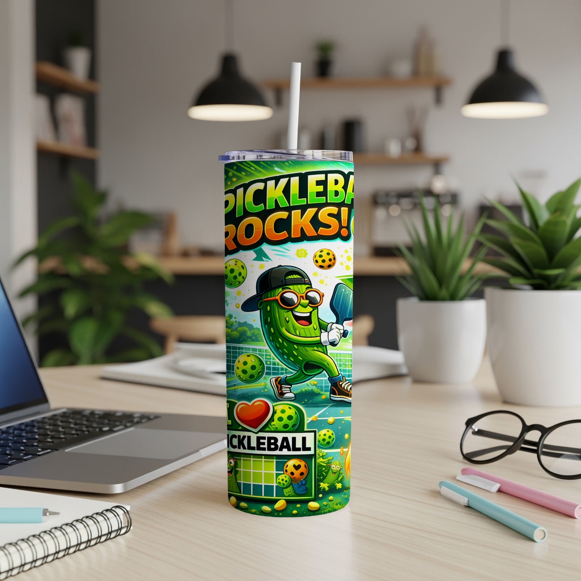 Pickleball tumbler with cartoon pickle mascot playing the sport.