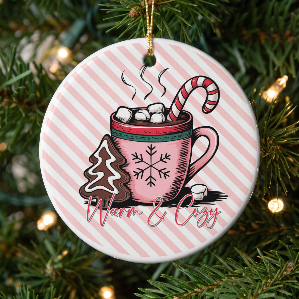Round ornament with hot chocolate, gingerbread tree cookie, and candy cane.