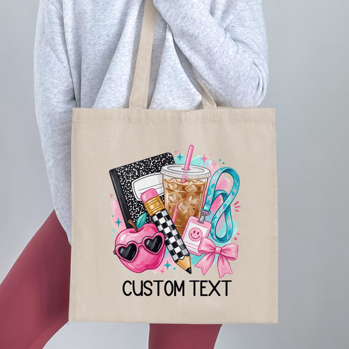 Tote bag with school supplies graphic and "CUSTOM TEXT" at bottom.