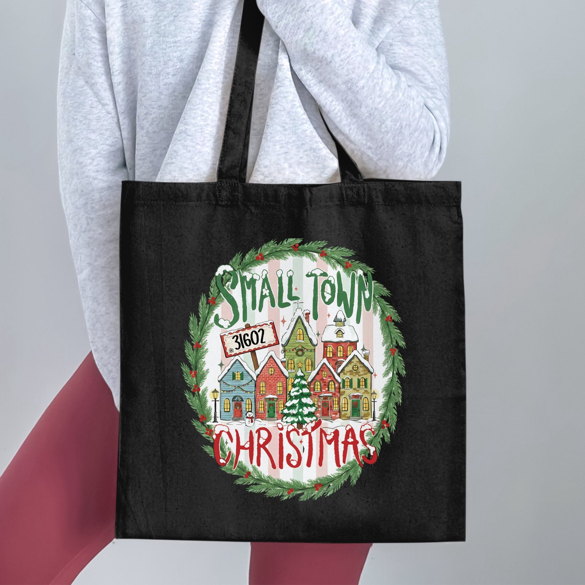 Black tote bag with a Christmas village design and the words "Small Town Christmas" and "31602".