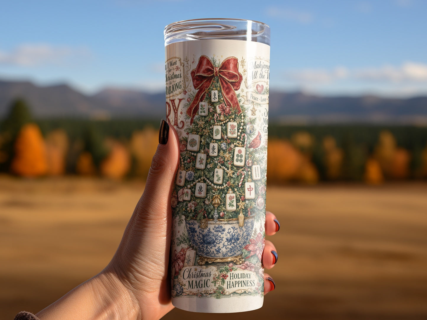 Candle with Mahjong Christmas tree design held against a blurred outdoor background.