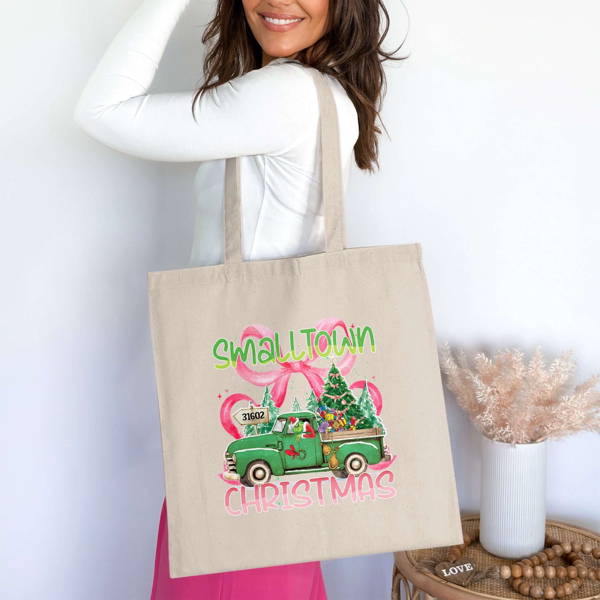 Tote bag with "Small Town Christmas" graphic featuring a green truck and Christmas tree.