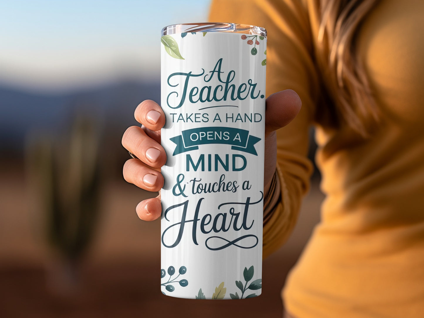 White tumbler with "A teacher takes a hand, opens a mind & touches a heart" text.