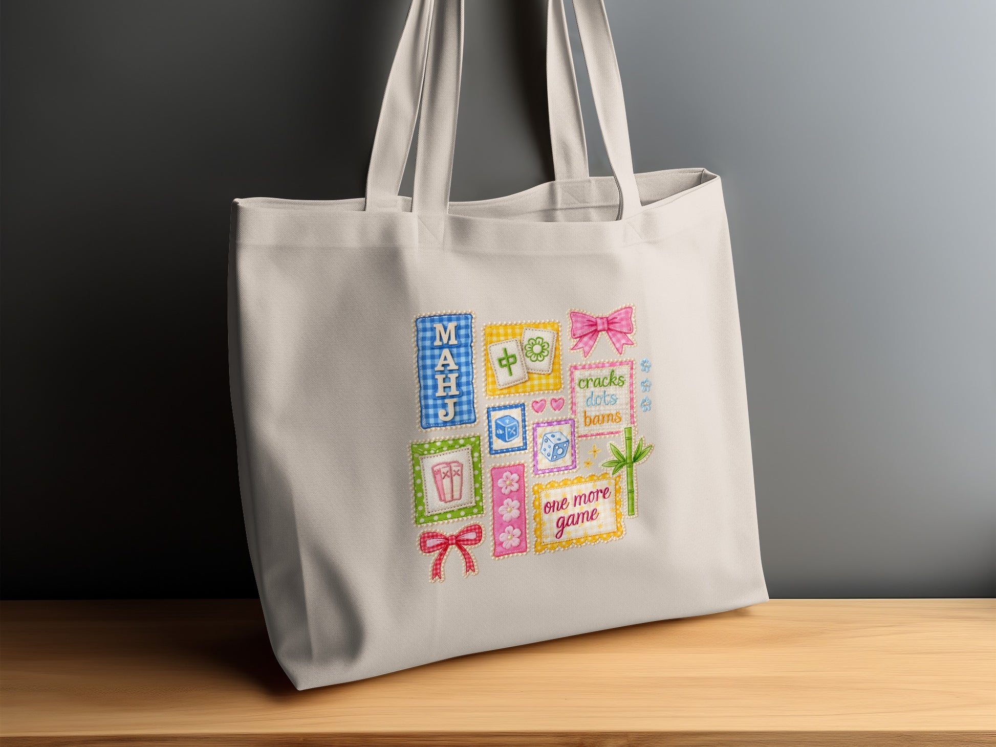Cream canvas tote bag with colorful embroidered patches including game tiles and dice.