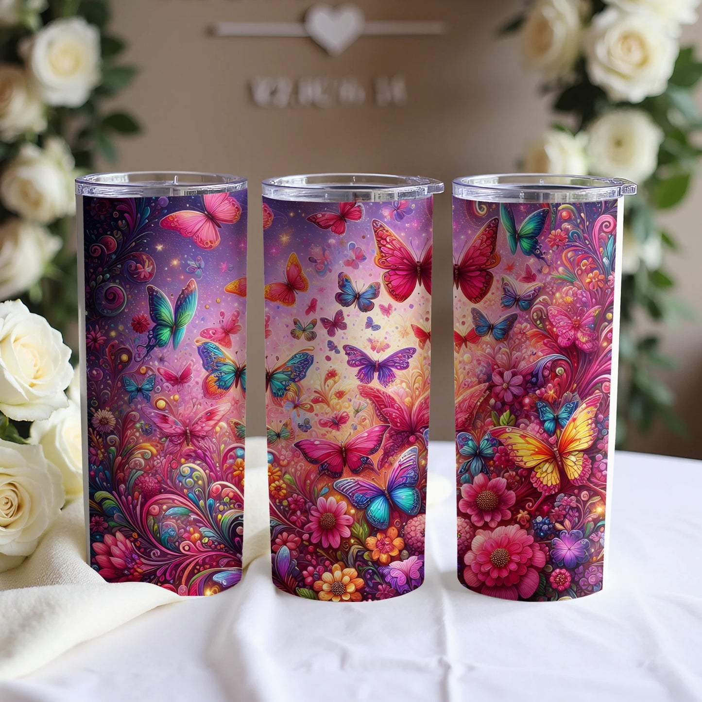 Three tumblers decorated with colorful butterflies and floral designs.