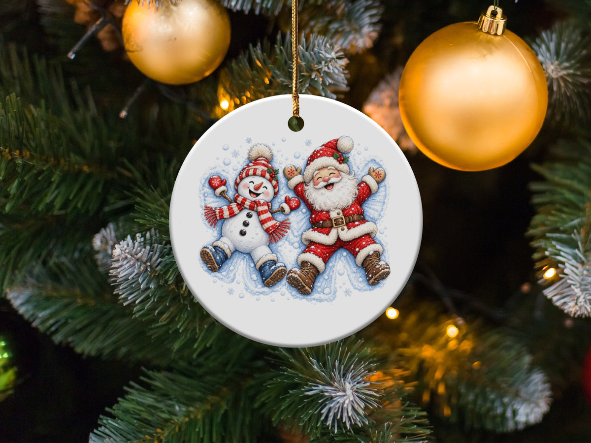 Round ornament featuring a cheerful Santa and snowman lying in the snow.
