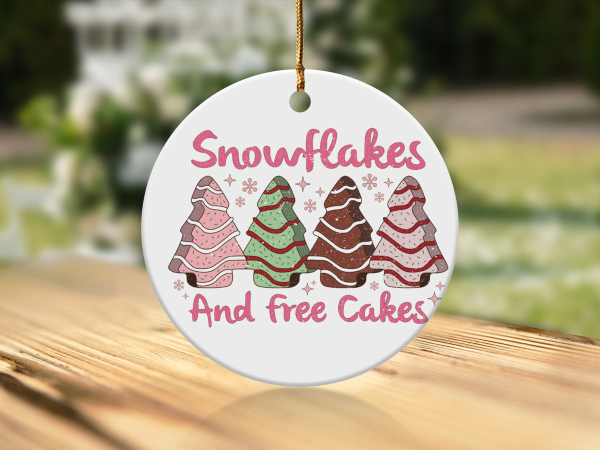 Round ornament with "Snowflakes And free Cakes" and four decorated Christmas trees.