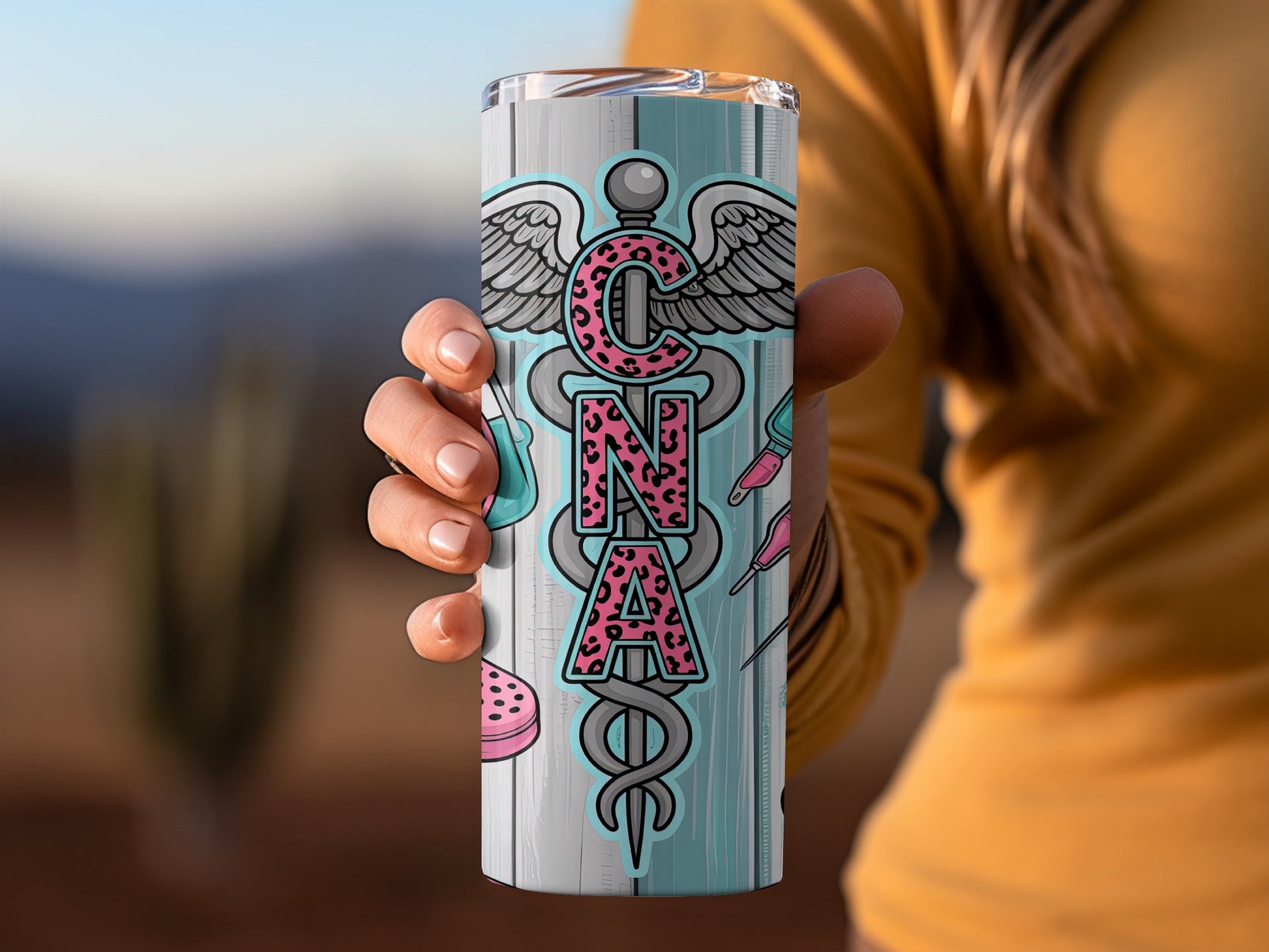 CNA tumbler with caduceus and medical icons on wood grain background.